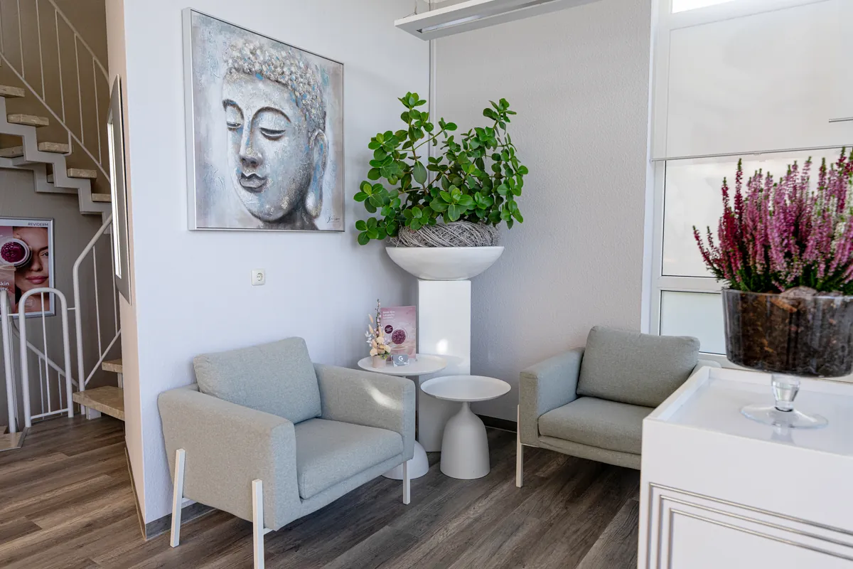Sitzecke mit Sesseln, Buddha-Bild und Pflanzen im Beratungsbereich von BodyFlair Werdau