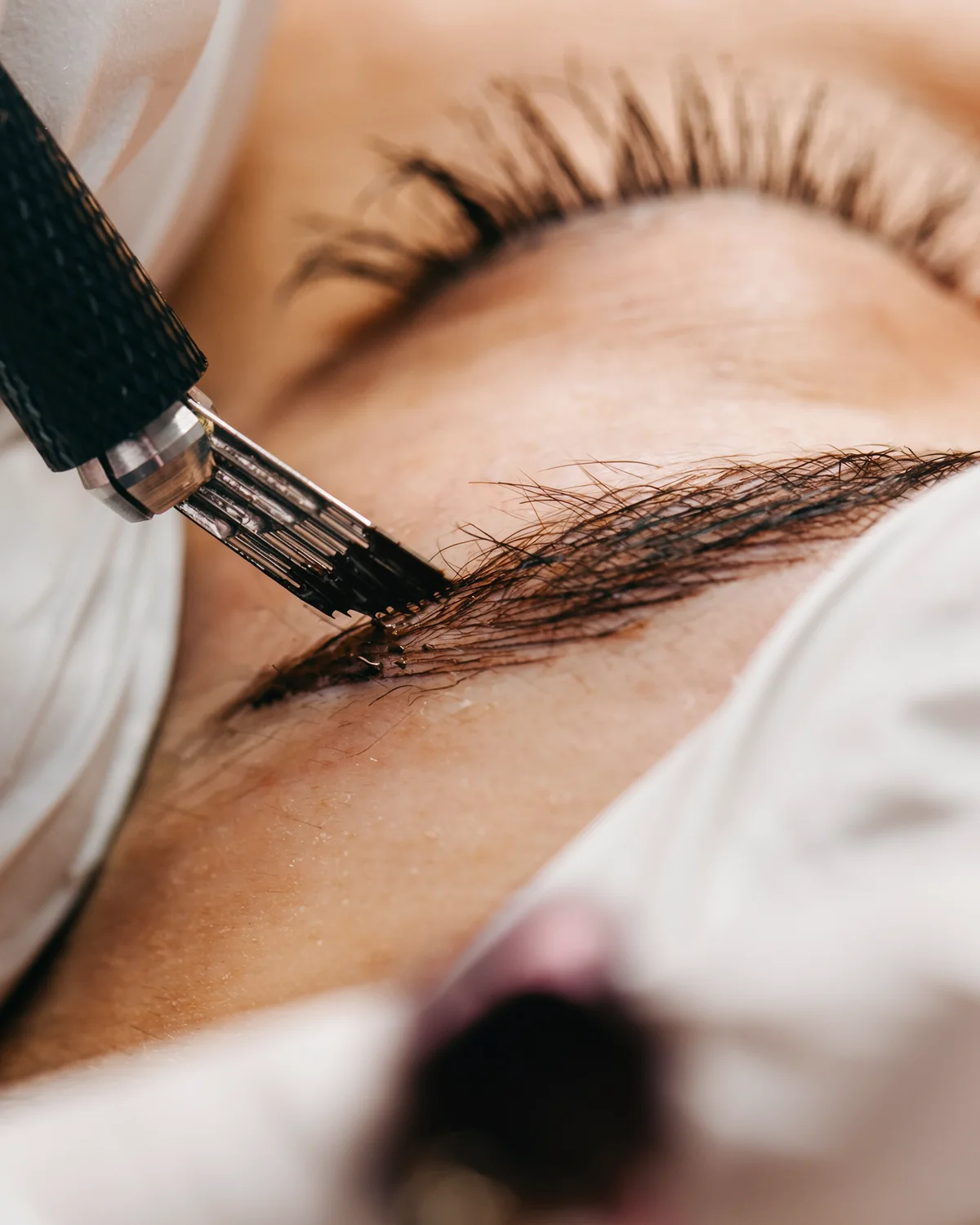 Microblading: Härchen für Härchen wird die Augenbraue mit der feinen Klinge nachgezeichnet, weiße Handschuhe