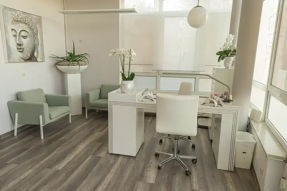 Beratungsplatz mit Sesseln, Schreibtisch und Orchideen