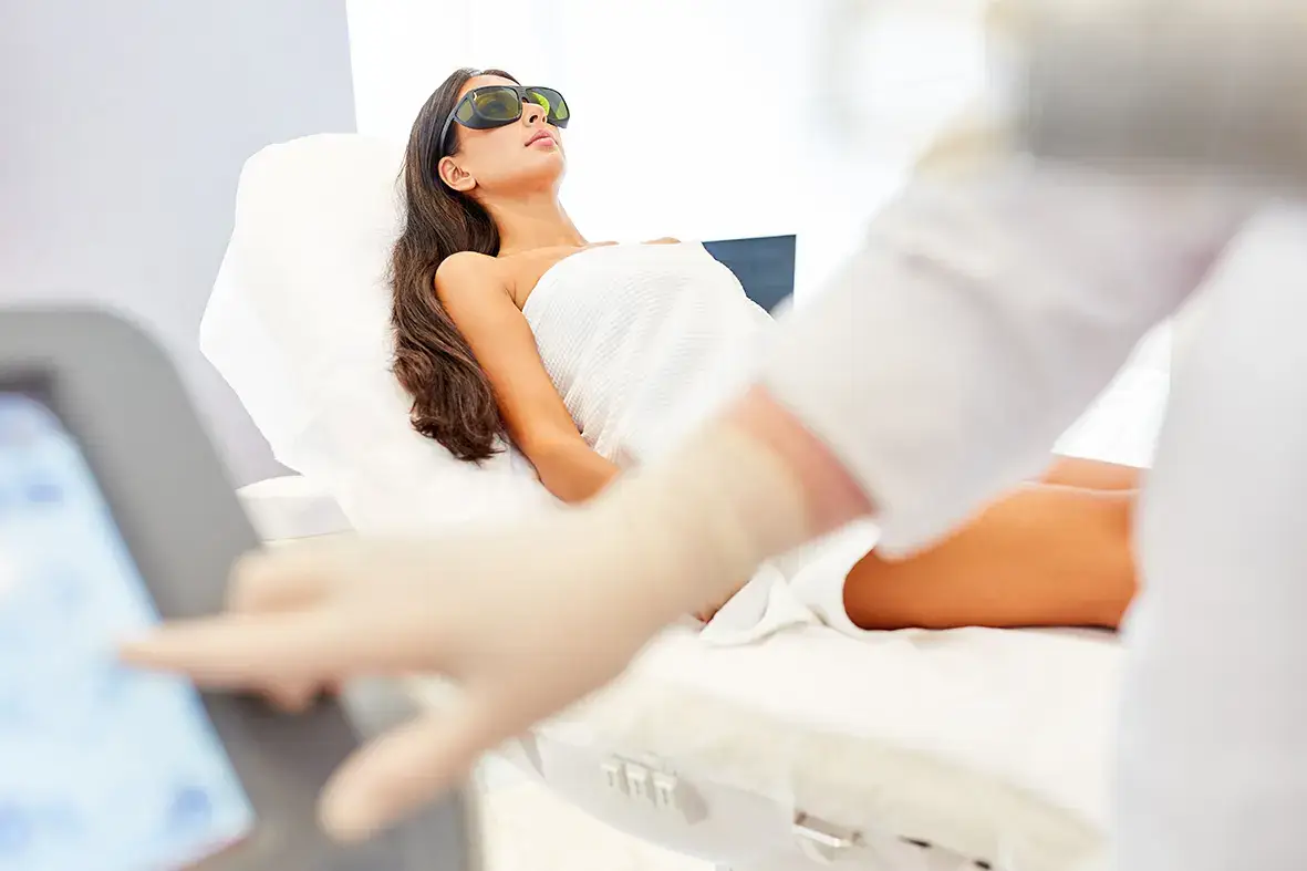 Dauerhafte Haarentfernung am Bein mit dem 3-Wellen-Diodenlaser, Kundin mit Schutzbrille