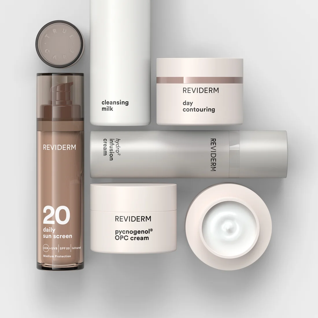 Pflegeprodukte von REVIDERM: Reinigungsmilch, Tagescreme, Infusionscreme, OPC-Creme und Sonnenschutz