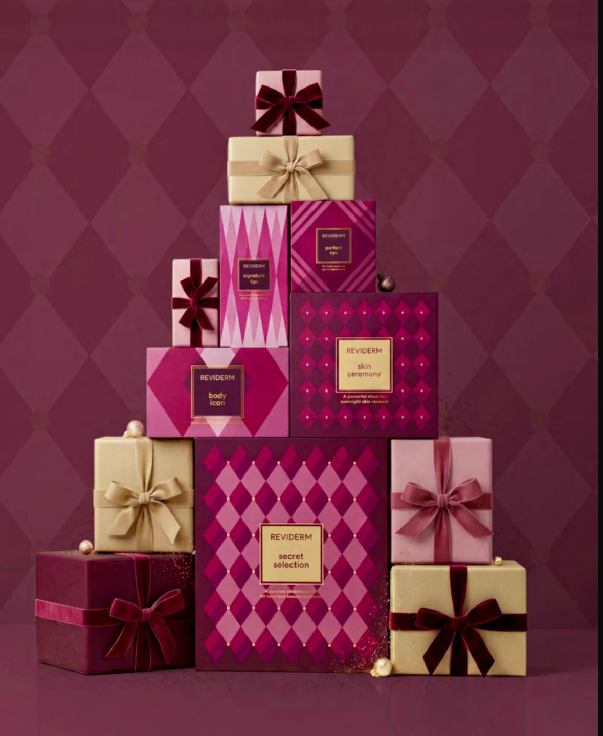 REVIDERM Adventskalender secret selection zwischen weihnachtlich verpackten Geschenken in Beerentönen